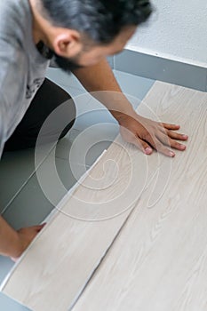 Kuala Lumpur, Malaysia - March 1, 2020: A man installing new vinyl tile floor, a DIY home project