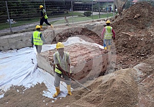 Underground drainage manhole under construction by construction workers at the construction site.