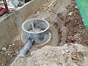 Underground drainage manhole under construction by construction workers at the construction site.
