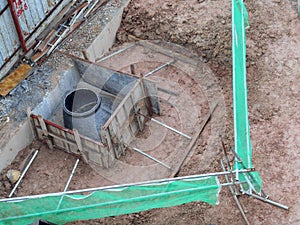 Underground drainage manhole under construction by construction workers at the construction site.