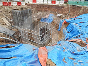 Underground drainage manhole under construction by construction workers at the construction site.