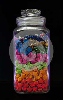 Kuala Lumpur, Malaysia - May 11, 2020 :Multicolored Origami or paper star in glass jar on black background. Fold the paper star