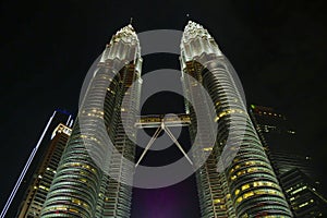 KUALA LUMPUR / MALAYSIA - 2019 : Night view of the impressive Petronas twin towers and bridge at Kuala Lumpur KLCC area