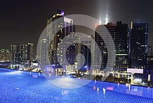 Kuala Lumpur night scene cityscape,and illuminated swimming pool on roof,Malaysia