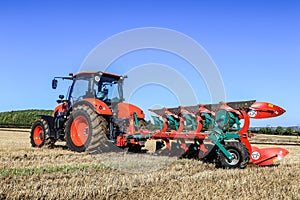 Kubota M7-173 ploughing on stubble in crop field