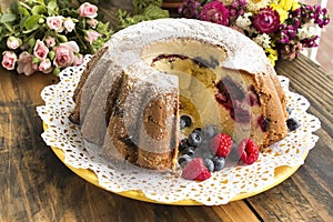 Kugelhopf with Berries on a Rustic Wooden Table