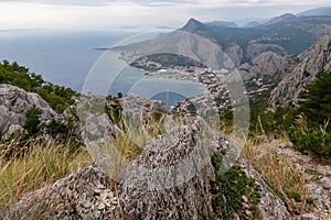 Kula - Scenic aerial view of coastal town Omis surrounded by Dinara mountains in Split-Dalmatia, South Croatia. Hiking trail