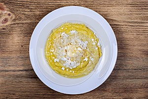 Kulesha - Hutsul corn porridge, cooked on water, served with cheese, butter, cheese and sour cream on the plate, Western Ukraine