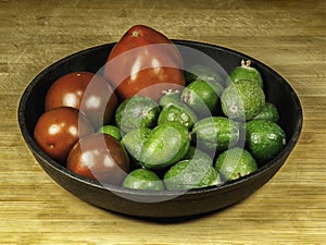Kumato tomatoes and feijoa in dark gray plate