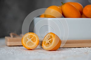 Kumquat in a cup on a pink background, acidic