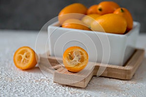 Kumquat in a cup on a pink background, sour