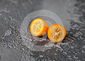 Kumquat fruit cut on the table, two halves