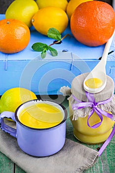 Kurd. Lemon custard and fresh lemons, oranges and mint on old wooden table. photo