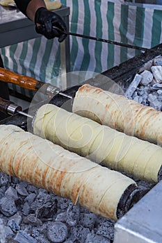 Kurtos kalacs or chimney cakes, preparing on charcoal grill, street food traditional Hungarian