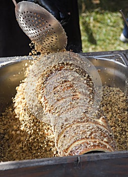 Kurtos kalacs or chimney cakes, preparing on charcoal grill, street food traditional Hungarian