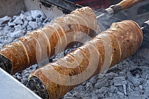Kurtos kalacs or chimney cakes, preparing on charcoal grill, street food traditional Hungarian