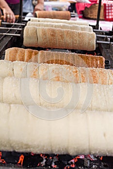 Kurtos kalacs or chimney cakes, preparing cooking on charcoal grill