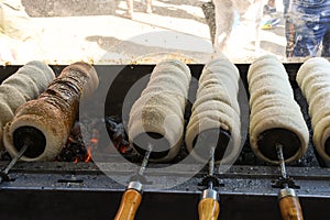 Kurtos kalacs or chimney cakes, preparing cooking on charcoal grill