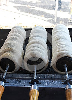 Kurtos kalacs or chimney cakes, preparing cooking on charcoal grill