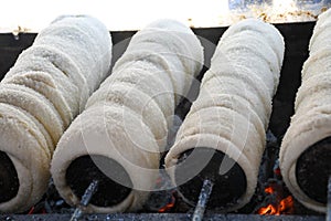 Kurtos kalacs or chimney cakes, preparing cooking on charcoal grill
