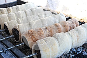 Kurtos kalacs or chimney cakes, preparing cooking on charcoal grill