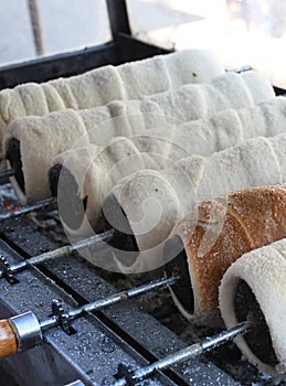 Kurtos kalacs or chimney cakes, preparing cooking on charcoal grill