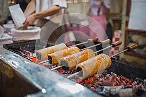 Kurtos kalacs or Chimney Cakes roll spinning over hot coals at a market stand,the typical sweet of Budapest,Hungary
