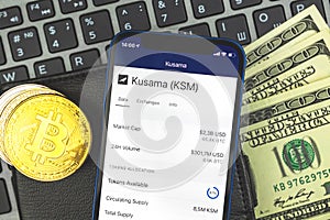 Kusama KSM cryptocurrency trade and sell with your mobile phone concept, bitcoin on leather wallet with dollars