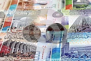 Kuwaiti dinar coins on the background of banknotes