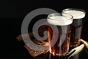 Kvass, bread and spikes on black background