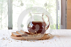 Kvass (kvas) in a transparent jug and rye bread