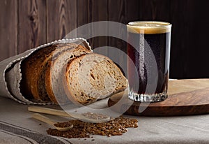 Kvass with rye wholegrain bread on wooden background.