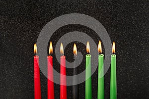 Kwanzaa festival concept with seven candles red, black and green on black background,