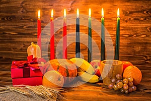 Kwanzaa holiday concept with traditional lit candles, gift box, photo