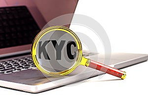 KYC word on magnifier on laptop , white background