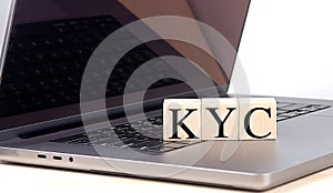 KYC word on wooden block on laptop , business concept photo