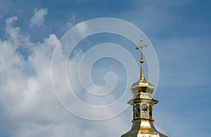 Kyiv. The golden dome of an ancient church next to a large white cloud against a blue sky