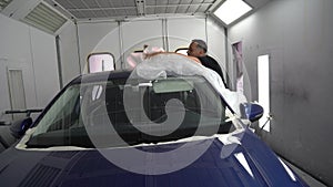 Kyiv, Ukraine - August 12, 2023: Paint shop at the car service station. The master of the paint shop prepares the car for painting