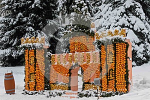 KYIV, Ukraine - December 25, 2018. A citrus castle built from thousands of fresh orange and lemons in a snowy winter coniferous fo