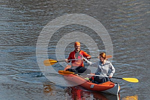 Kyiv Ukraine, the Dnieper River - March 29 2020: A pair of happy young people are swimming on oars in a kayak.