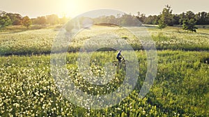 Kyiv, Ukraine, Europe. Traveler girl ride bicycle aerial. Sun field. Nature landscape