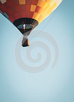 Hot air balloon in clear blue sky, vertical, filtered. Colorful balloon with basket lift up, toned with vignette.