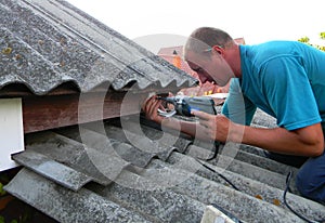 KYIV, UKRAINE - Septe, 27, 2019: Contractor installing plastic roof gutter holder. Plastic Roof Guttering, Rain Guttering &