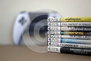 KYIV, UKRAINE - SEPTEMBER 17, 2025 Stack of PS5 videogame disc boxes and modern dualsense edge gamepad