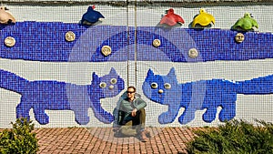 Kyiv - Young man sitting under a mosaic wall