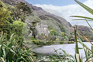 Kylemore Abbey surrounded by lush greenery by lake nestled against rugged hills in Connemara Ireland photo
