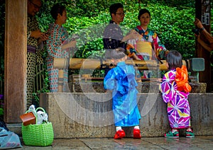 KYOTO, JAPAN - JULY 05, 2017: Young Japanese people wearing traditional Kimono and holding umbrellas in their hands in