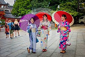 KYOTO, JAPAN - JULY 05, 2017: Young Japanese women wearing traditional Kimono and holding umbrellas in their hands in