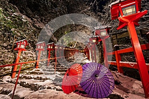 Kyoto, Japan. Kifune shrine in snowy winter night. Japanese umbrella on the stone stairs.