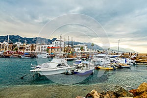 Kyrenia or Girne historical city center, view to marina with many yachts and boats with mountains in the background